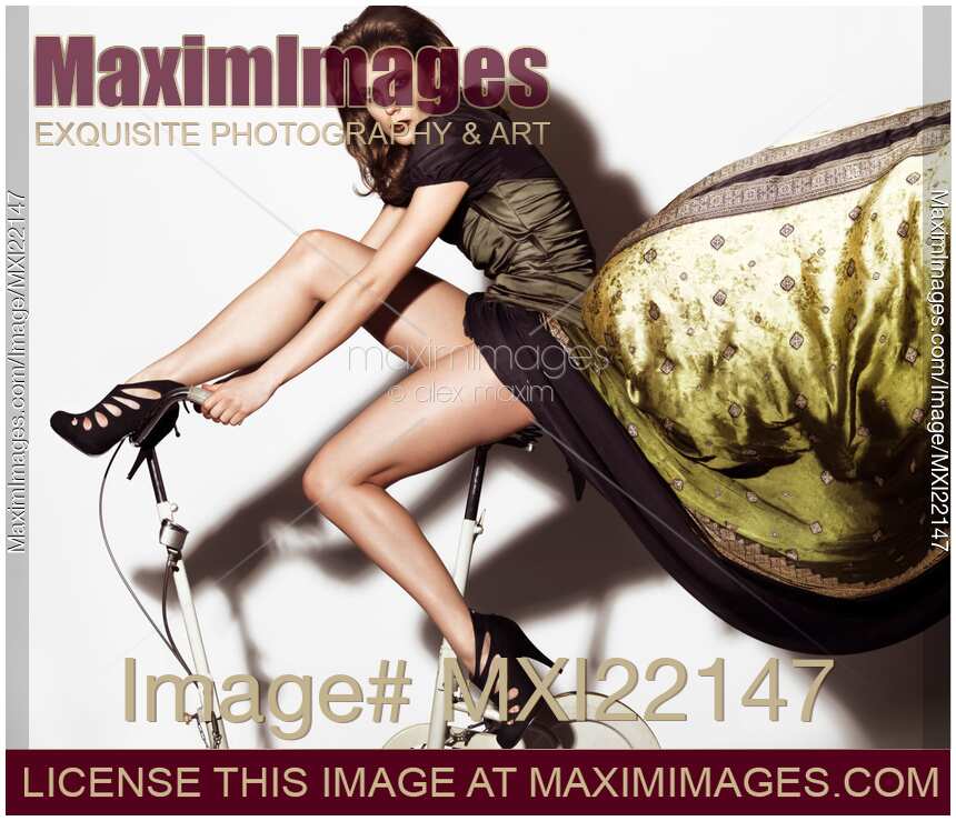 Young Woman in Long Dress on Exercise Bike
