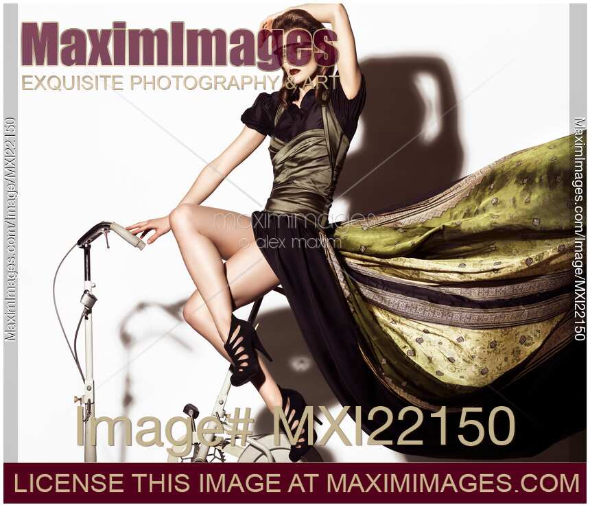 Young Woman in Long Dress on Exercise Bike