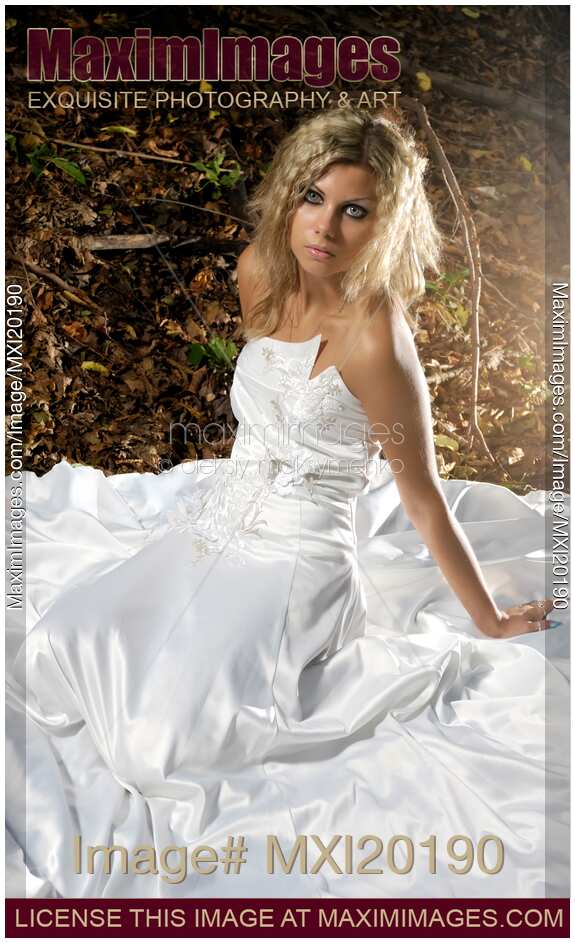 Young Woman in Wedding Dress Sitting on Fallen Leaves