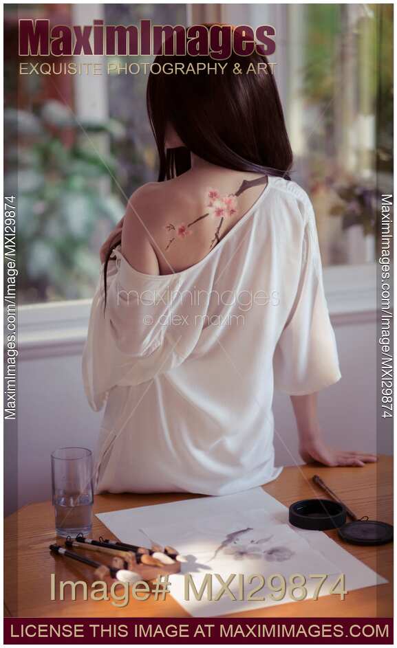 Young woman Japanese Sumi-e painter with a sakura blossom painting on her back