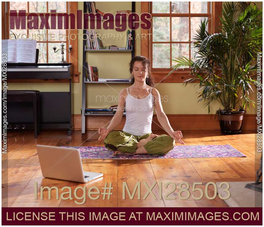 Young woman meditating at home in living room