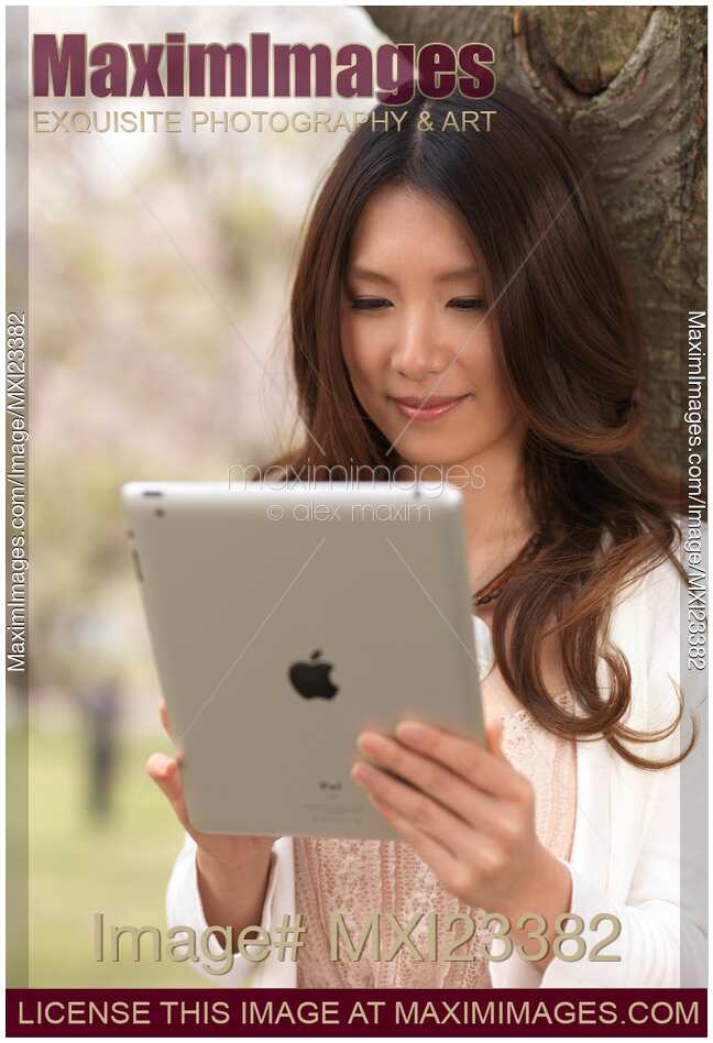 Young Woman Outdoors with iPad in Park