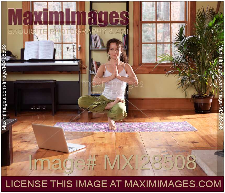 Young woman practicing yoga in living room at home
