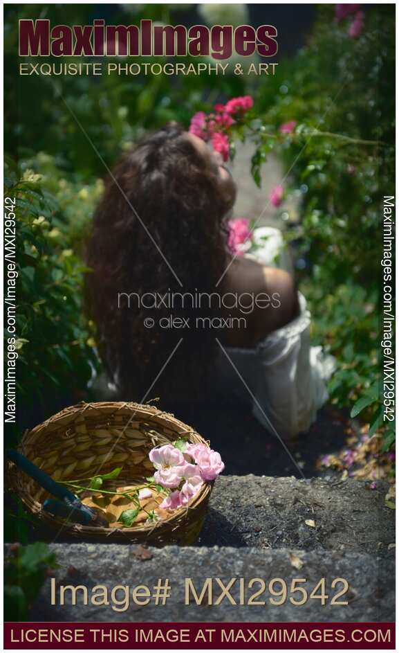 Young woman smelling roses in a garden