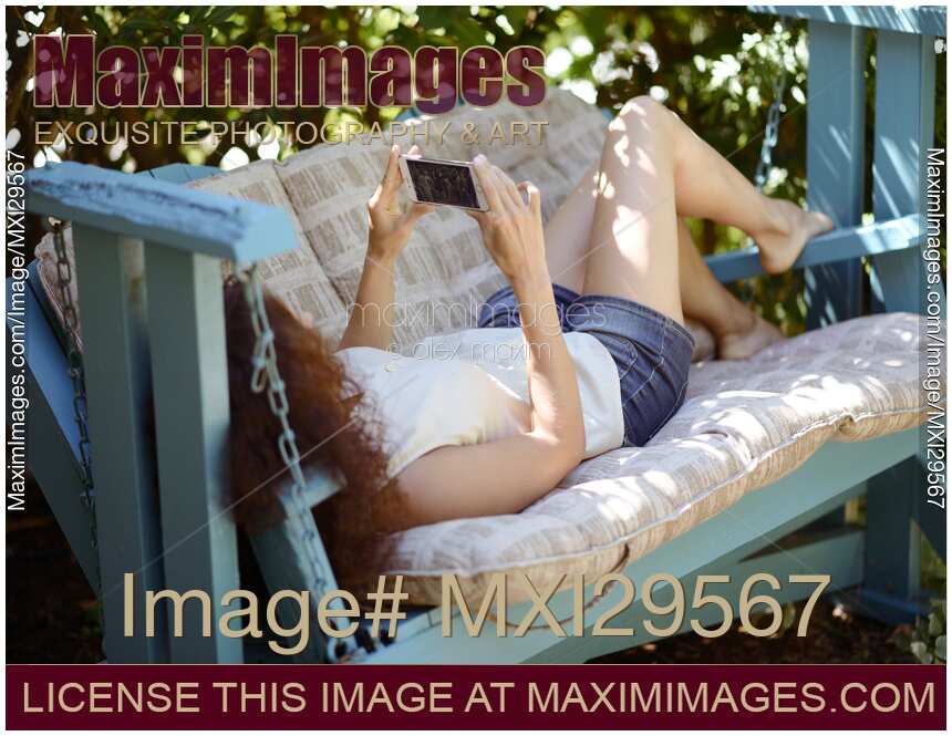 Young woman with an iPhone outdoors looking at the screen