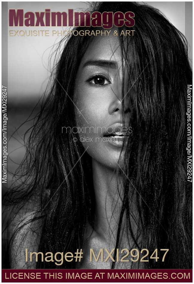 Young woman with long black hair covering her exotic face Black and white portrait