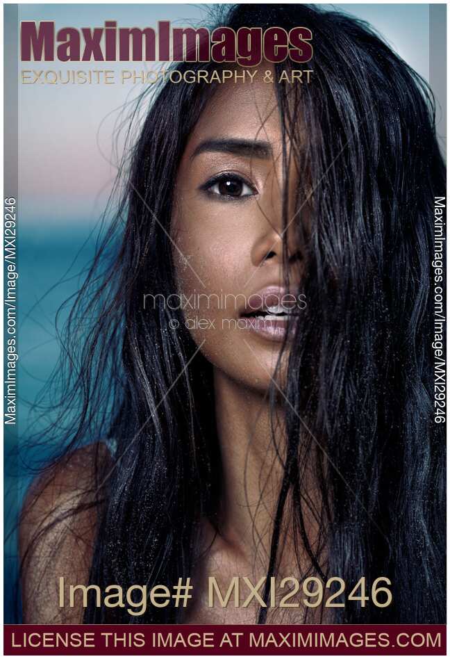 Young woman with long wet black hair covering her exotic face
