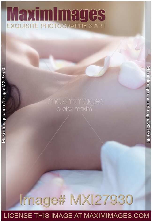 Young woman with pink rose petals on her body