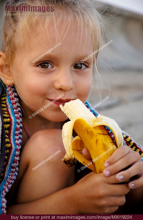 Stock photo of Portrait of child eating a banana Buy commercial use license at MaximImages
