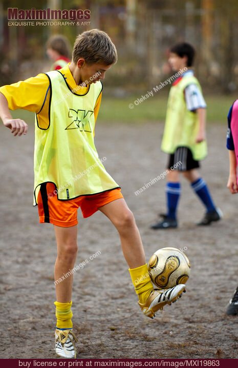 Stock photo of Boy practicing soccer in school Buy commercial use license at MaximImages
