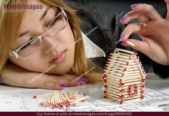 Stock photo of Young Woman Building a House from Matches Buy commercial use license at MaximImages