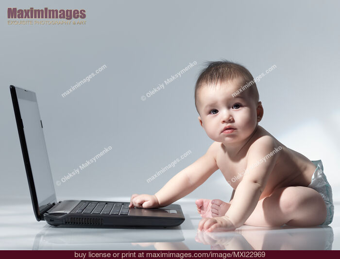 Stock photo of Baby Sitting in Front of a Laptop Buy commercial use license at MaximImages