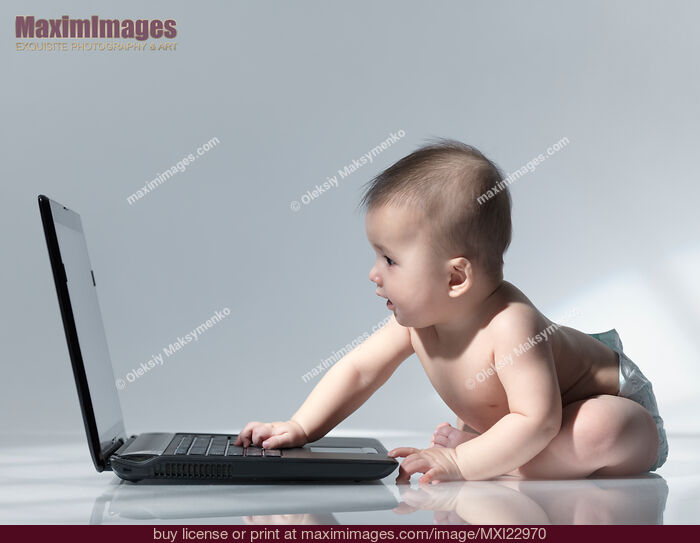 Stock photo of Baby Sitting in Front of a Laptop Buy commercial use license at MaximImages