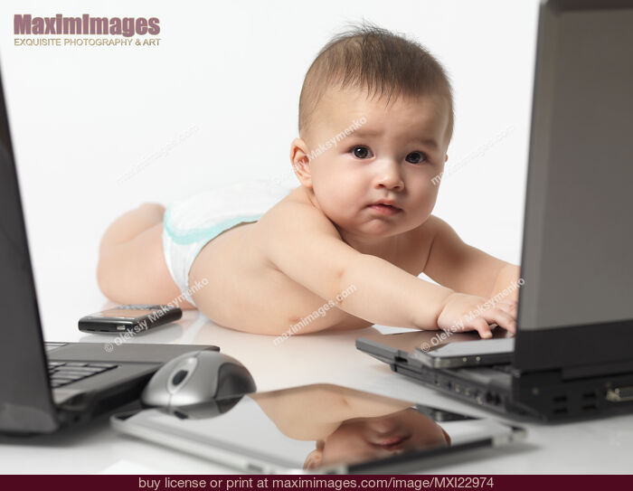 Stock photo of Baby amongst Computers and Electronics Buy commercial use license at MaximImages