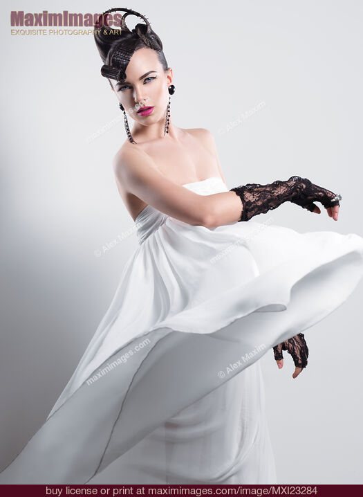 Stock photo of Beautiful Woman with a Creative Hairstyle Wearing a Long White Dress Buy commercial use license at MaximImages