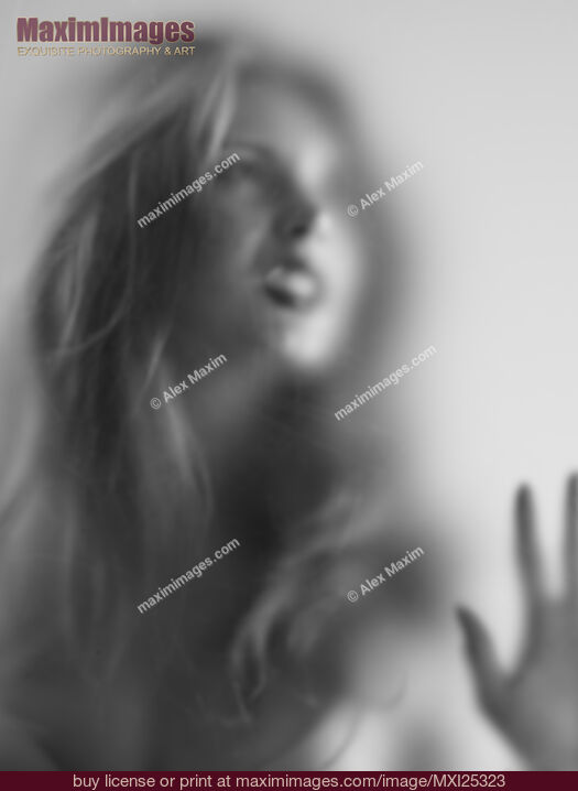 Stock photo of Young woman with angry expression behind glass Buy commercial use license at MaximImages