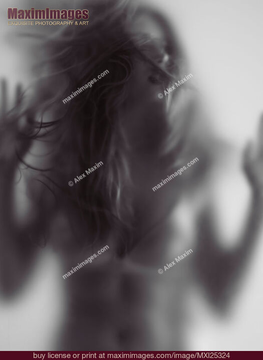 Stock photo of Young woman trapped behind glass Buy commercial use license at MaximImages