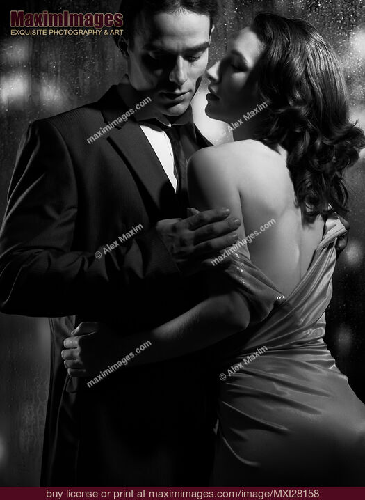 Stock photo of Beautiful portrait of couple standing near window on rainy night black and white Buy commercial use license at MaximImages