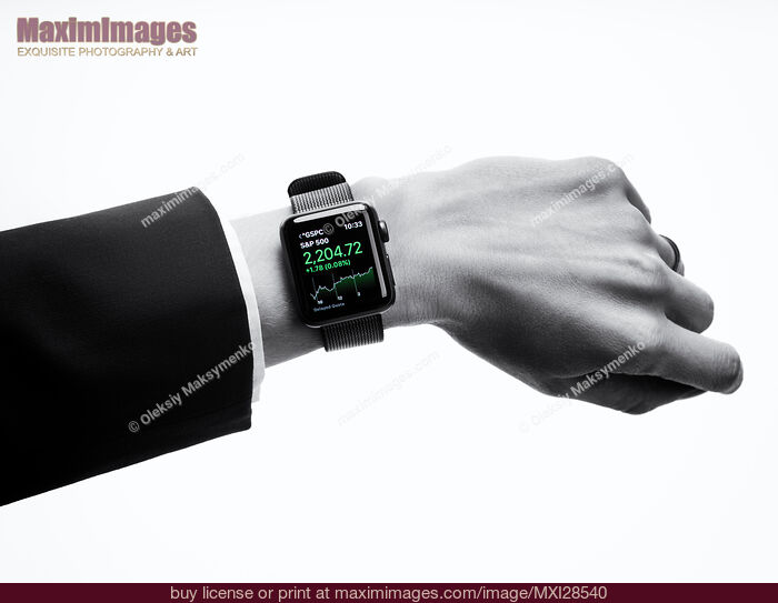 Stock photo of Woman hand with Apple Watch disaplying stock market app Buy commercial use license at MaximImages