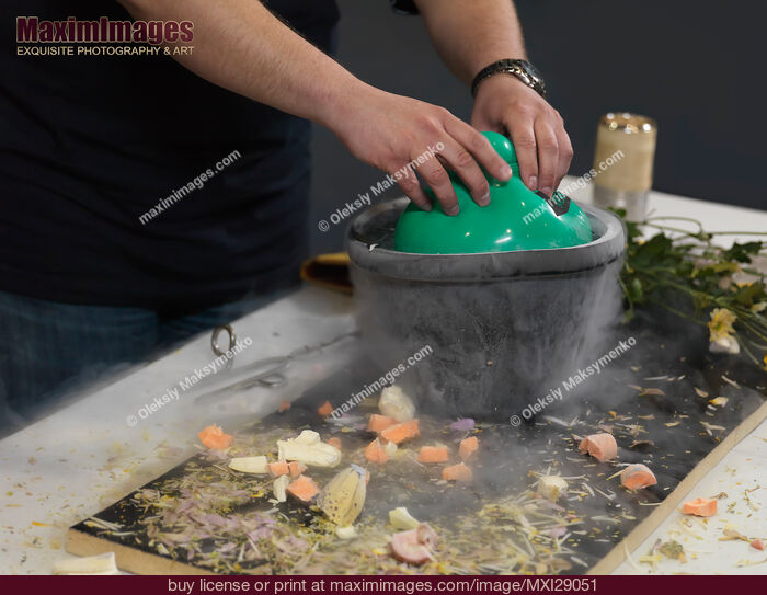 Stock photo of Person Submerging an Air Balloon into Liquid Nitrogen Buy commercial use license at MaximImages