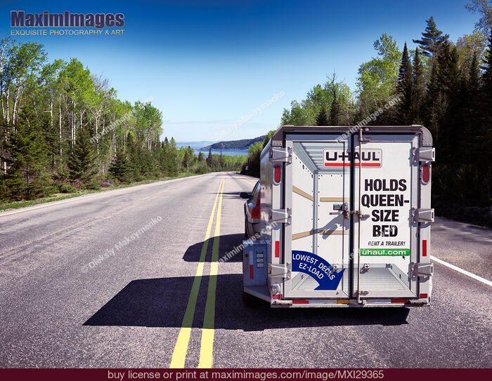 Car with a rental UHaul cargo trailer on a road. Stock Photo MXI29365