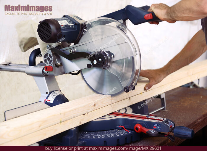 Person cutting wood lumber with miter saw. Stock Photo MXI29601