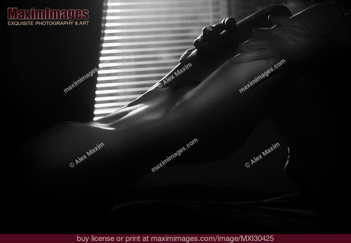 Stock photo of Black and white Erotic body parts of a sexy couple making love nude woman body with man hands on her thighs Buy commercial use license at MaximImages