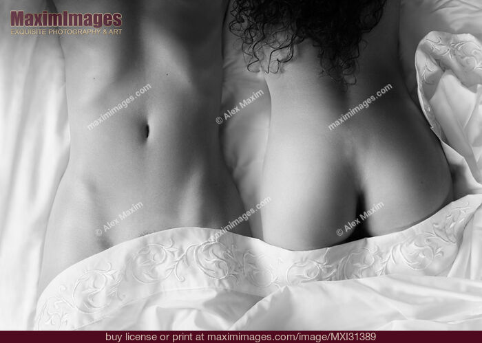 Stock photo of Sexy lesbian couple lying together on bed sheets sensual black and white close-up of naked bodies Buy commercial use license at MaximImages