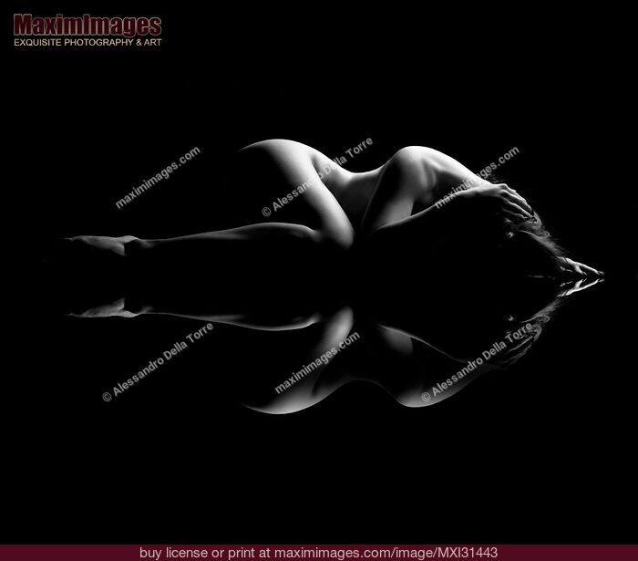 Stock photo of Nude body outline of a woman lying curled-up black and white Buy commercial use license at MaximImages