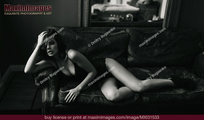 Stock photo of Beautiful sexy woman in lingerie lying on a leather couch Black and white Buy commercial use license at MaximImages