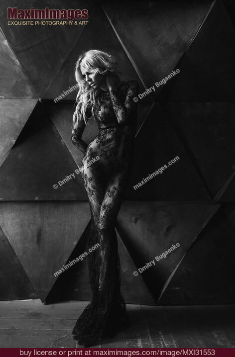Stock photo of Dramatic sexy portrait of a beautiful blond woman in black lacy bodystocking dress over naked body Buy commercial use license at MaximImages