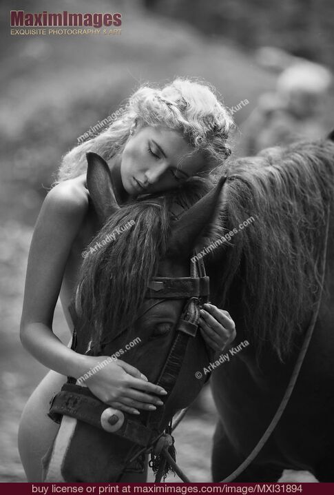 Stock photo of Fine art black and white photograph of a naked woman hugging a horse in the forest Buy commercial use license at MaximImages
