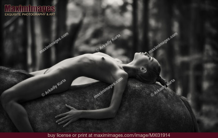 Stock photo of Romantic fine art black and white nude photograph of a young woman lying on the horse Buy commercial use license at MaximImages