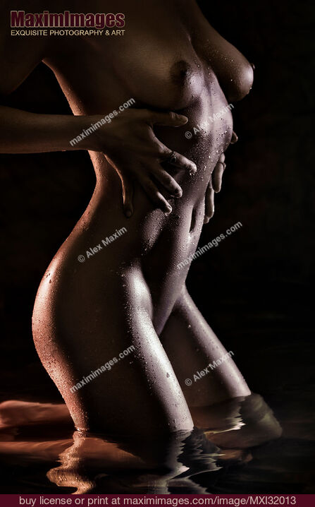 Stock photo of Sexy wet nude woman body with hands on her dark shiny metallic skin standing in water Buy commercial use license at MaximImages