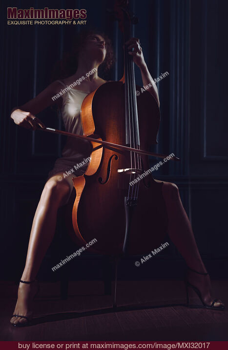 Stock photo of Beautiful sensual woman passionately playing cello in dim dramatic night time settings Buy commercial use license at MaximImages