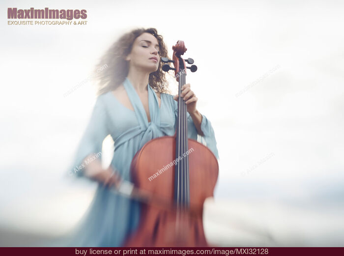 Stock photo of Young woman thoughtfully playing cello in a bright sunrise outdoor scenery Buy commercial use license at MaximImages