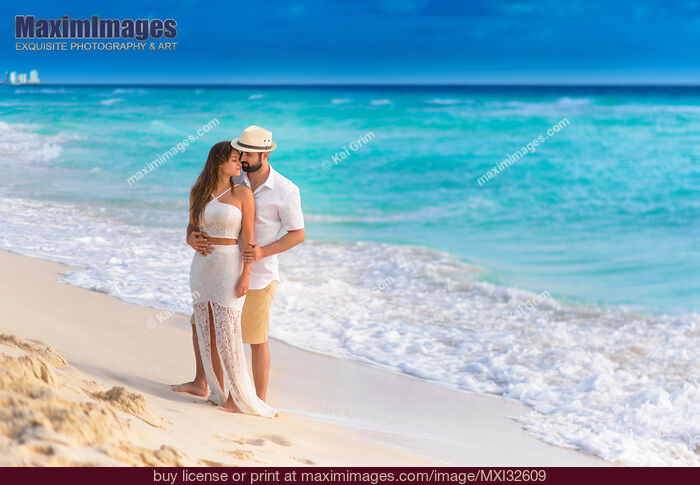 Stock photo of Couple together in an embrace on a sunny sandy sea shore of a Caribbean Sea beach in Cancun Mexico Buy commercial use license at MaximImages