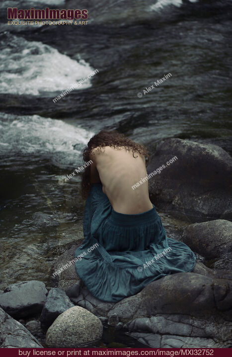 Mujer sentada acurrucada junto al río con la espalda desnuda expuesta Fotografía dramática de bellas artes Foto de stock de Mujer sentada acurrucada junto al río con la espalda desnuda expuesta Fotografía dramática de bellas artes Compre licencia de uso comercial en MaximImages