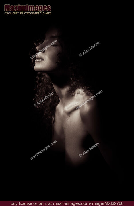 Stock photo of Sensual portrait of a woman face and bare chest closeup in dramatic light Black and white Buy commercial use license at MaximImages