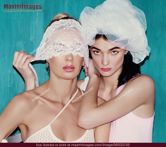 Stock photo of Sensual portrait of two young sexy women playing with a white lace Buy commercial use license at MaximImages