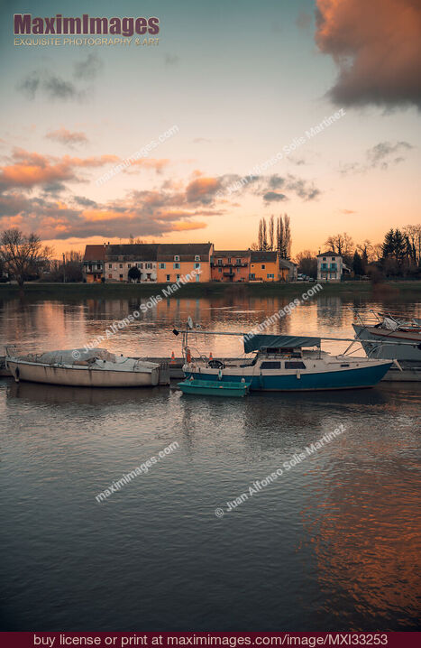 Stock photo of Boats in sunset scenery at Tournus town on the Saône River in France Buy commercial use license at MaximImages