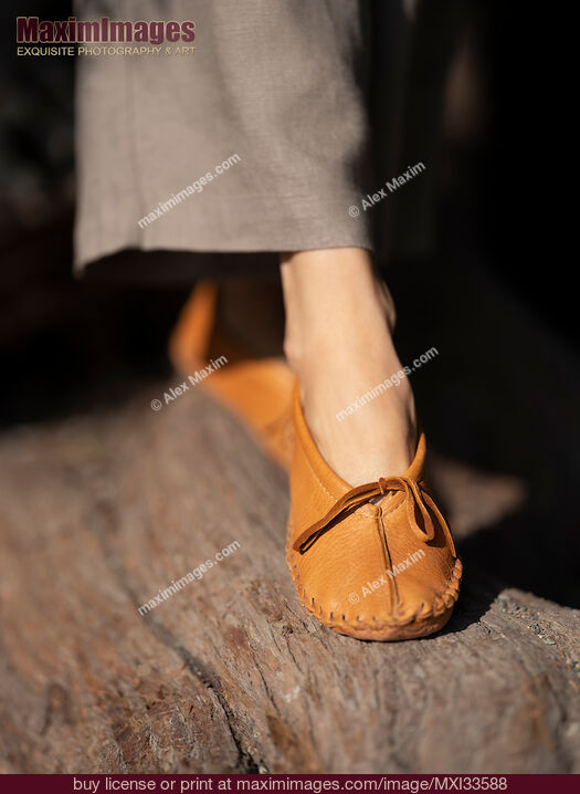 Stock photo of Closeup of woman feet in deer hide deerskin leather moccasins walking in the nature Buy commercial use license at MaximImages