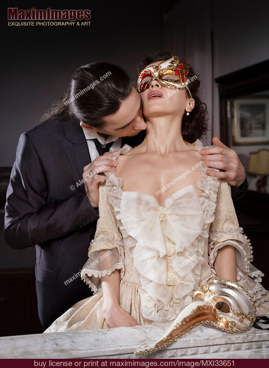 Stock photo of Romantic couple, man caressing and kissing beautiful lady in carnival mask and vintage Venetian dress. Casanova seduction concept. Buy commercial use license at MaximImages