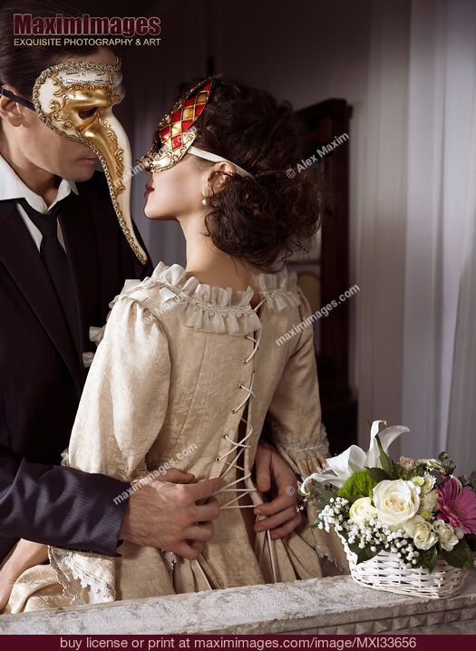 Stock photo of Sensual portrait of a couple in vintage Venetian carnival costumes. Man unlacing corset dress back of a beautiful woman. Buy commercial use license at MaximImages