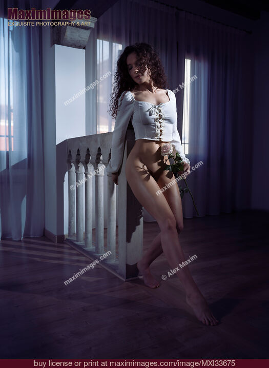 Stock photo of Beautiful young woman dancing half-naked with a rose in dark room Buy commercial use license at MaximImages
