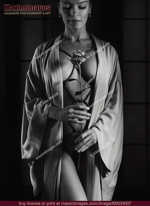 Stock photo of Woman with ropes of Shibari bondage tied around her sensual naked body holding a rose Art nude black and white Buy commercial use license at MaximImages
