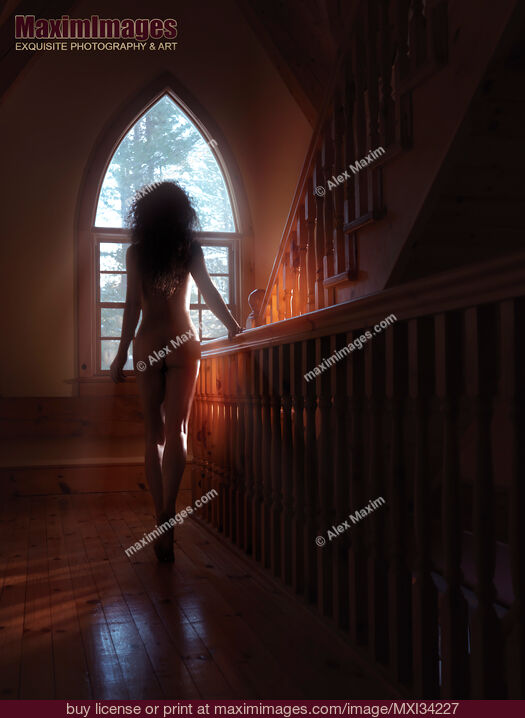 Stock photo of Rear view silhouette of beautiful naked woman walking to a staircase window in dim sunlight Buy commercial use license at MaximImages
