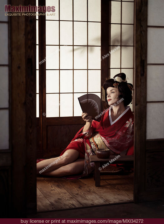 Stock photo of Beautiful caucasian lady, Japanese geisha sitting with hand fan in a sensual pose with her legs bared Buy commercial use license at MaximImages