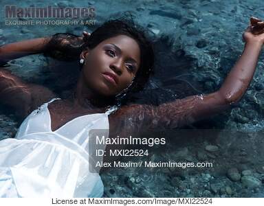 Young Woman in White Dress Lying in Water... preview image