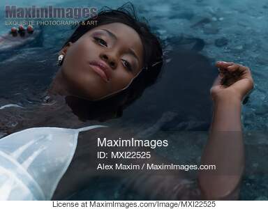 Young Woman in White Dress Lying in Water... preview image